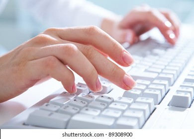 Female hands typing on white computer keyboard