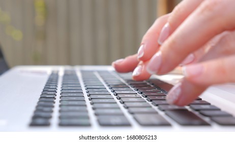 Female hands typing some text on keyboard of notebook. Unrecognizable woman working at laptop outdoors. Girl chatting with somebody or browsing internet. Freelancer using pc. Close up Side view - Shutterstock ID 1680805213