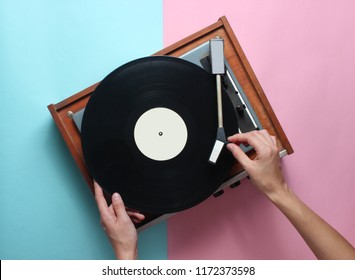 Female hands  use retro vinyl player on a blue pink pastel background. DJ. Top View - Shutterstock ID 1172373598
