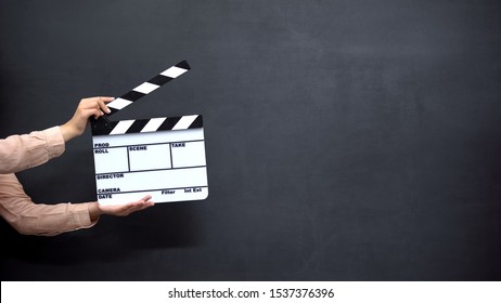 Female hands using clapperboard against black background, shooting movies - Shutterstock ID 1537376396