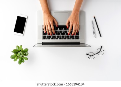 Female Hands Using Laptop On White Background With Accessories. Office Desktop. Top View