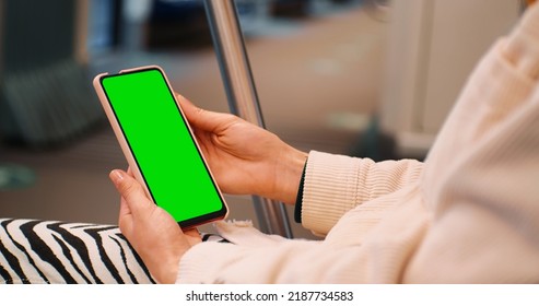 Female Hands Using Smartphone With Green Screen Mock Up Display On Subway. Woman Watching On The Phone On The Underground. Technology In Life.