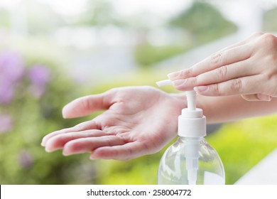 Female hands using wash hand sanitizer gel pump dispenser. - Powered by Shutterstock