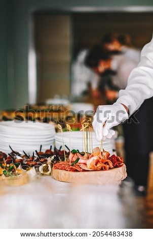 female hands of a waiter prepare food for a buffet table in a restaurant