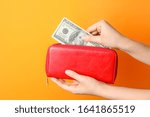 Female hands with wallet and money on color background