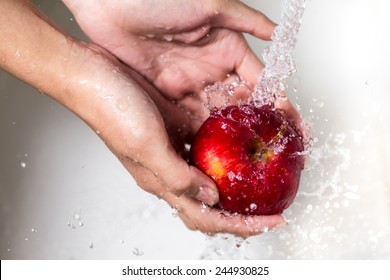 Female hands washing apple