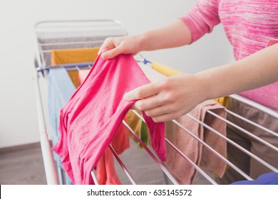 Female hands with wet clothes. A woman hangs up wet clothes after washing. Women's hands and wet clothes