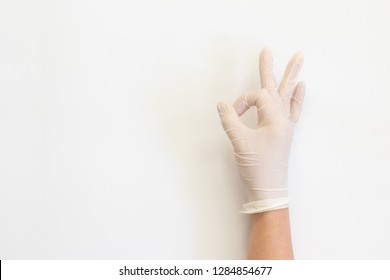 Female hands in white medical gloves showing like sign. 