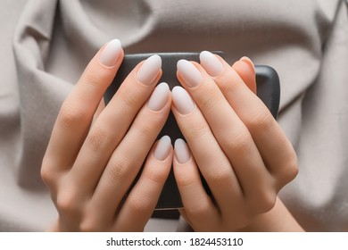 Female Hands With White Nail Design. White Nail Polish Manicure. Female Hands Holding Grey Coffee Cup.