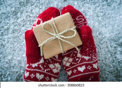 Female Hands In Winter Gloves With Christmas Gift Box