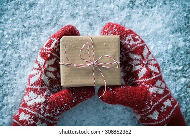 Female Hands In Winter Gloves With Christmas Gift Box