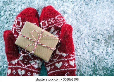 Female Hands In Winter Gloves With Christmas Gift Box