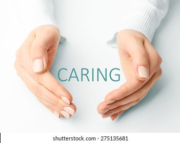 Female hands with word caring on light background