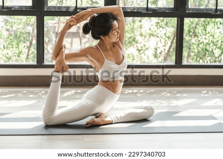 Female happiness Attractive young asian woman doing yoga stretching exercise on mat yoga fitness exercises. Healthy lifestyle Calmness and relax at home