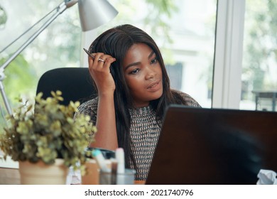 Female Head Of Digital Marketing Department Scratching Her Head When Reading Contract Details On Laptop Screen