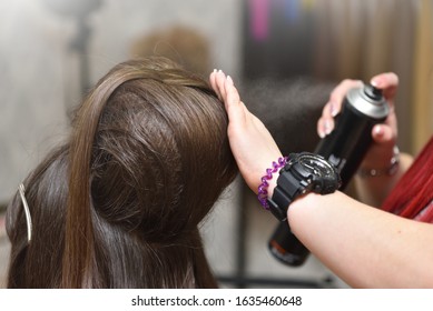 Female head and hair spray. The girl the hairdresser applies hair spray when creating a voluminous hairstyle in a beauty salon. - Shutterstock ID 1635460648