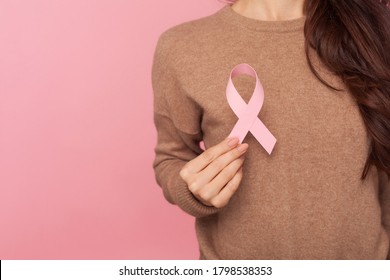 Female health check awareness. Closeup of young woman in pullover holding pink ribbon, symbol of breast cancer, - Shutterstock ID 1798538353