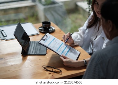 Female health insurance broker presenting his insurance benefits to businessman fill out insurance policy. To prevent future incidents. - Shutterstock ID 2128874558