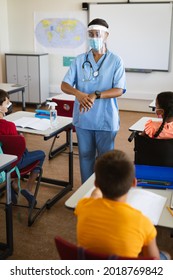 Female Health Worker Showing Students To Use Hands Sanitizer In Class At Elementary School. Education Back To School Health Safety During Covid19 Coronavirus Pandemic.