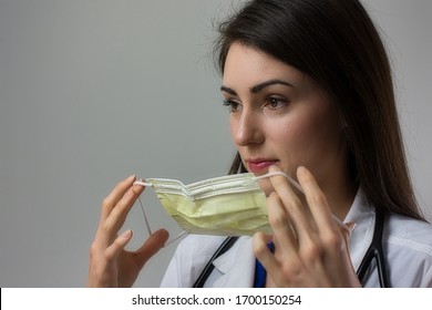 Female Healthcare Worker Putting On Mask. Donning PPE For Safety In Hospital. Could Be Nurse Practitioner, MD, PA, Nurse, Doctor, DO, Etc.