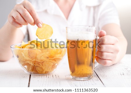 Female with heap of potato chips in big dish