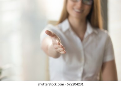 Female helping hand extended at camera for handshake, welcoming to cooperation concept, inviting at meeting, medical consultation, job interview, open to cooperation, good first impression, close up