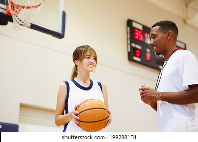 Female High School Basketball Player Talking With Coach