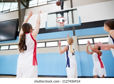 Female High School Basketball Team Shooting At Basket On Court