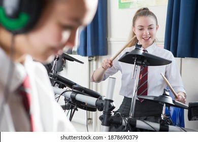 Female High School Student Playing Drums During A Music Class.