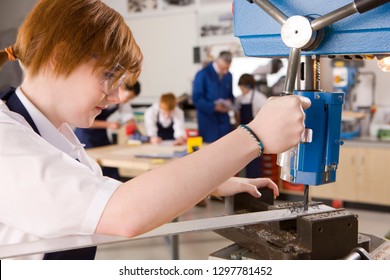 Female High School Student Using Drill In Metalwork Class