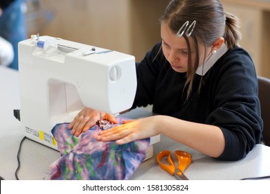 Female High School Student Using Sewing Machine In Textiles Class