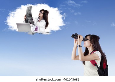 Female High School Student Using Binoculars To Look At Her Future Job As A Doctor