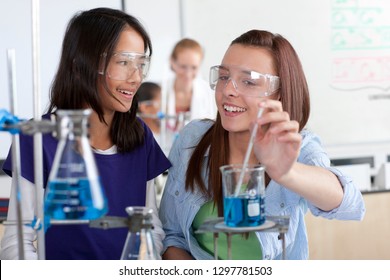 Female High School Students Performing Experiment In Chemistry Lab