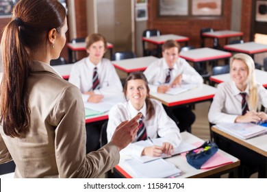 Female High School Teacher Teaching In Classroom