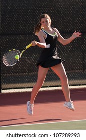 Female High School Tennis Player Hits Forehand Shot