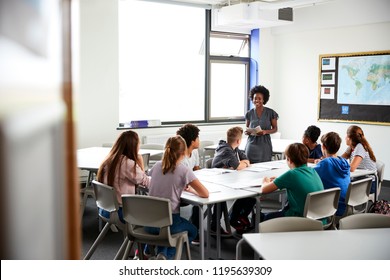 Female High School Tutor Standing By Table With Students Teaching Lesson - Shutterstock ID 1195639309