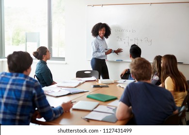 Female High School Tutor At Whiteboard Teaching Maths Class - Powered by Shutterstock