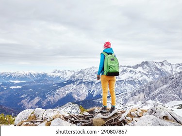 Female hiker with backpack standing on top of mountain