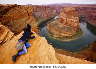 A female hiker climbing up the Horseshoe Bend in Arizona in the cold weather conditions - January 2017 - Shutterstock ID 623546309