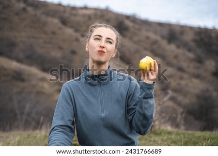 Female hiker eating apple during a long day backpacking, healthy camping journey adventure concept