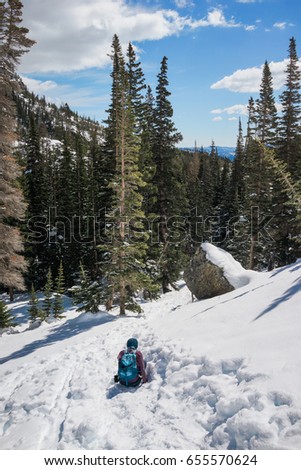 A female hiker fell into snow  in the mountain with snow in winter.