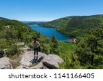 Female hiker reaching the top of an overlook of Jordan Pond at Acadia National Park 