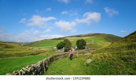 A Female Hiker Walking Through The Countryside Of Coquetdale In Northumberland, England.