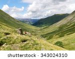 A female hiker walking towards Hartsop and Brock Crags  in the English Lake District, UK.                               