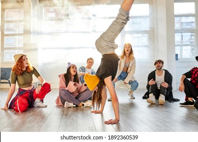 Female Hip Hop Dancer In Motion, Standing Upside Down, Showing Break Dance For People Surrounding Dancer, Performance In Studio