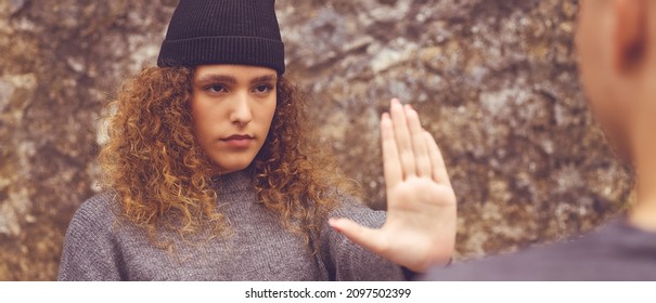 Female hipster young adult gesturing stop and distance to male friend outdoor in city - Shutterstock ID 2097502399