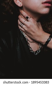 A Female Hispterwearing A Thick Chain Necklace, Silver Rings, And A Black Bracelet