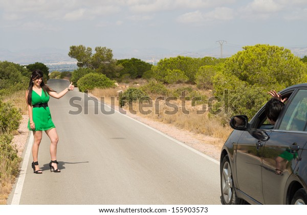Female\
hitchhiker being successful in stopping a\
car