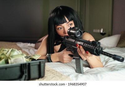 A Female Hitman In A Hotel Lies On A Bed And Holds An Automatic Rifle With A Telescopic Sight On The Victim While Committing Murder