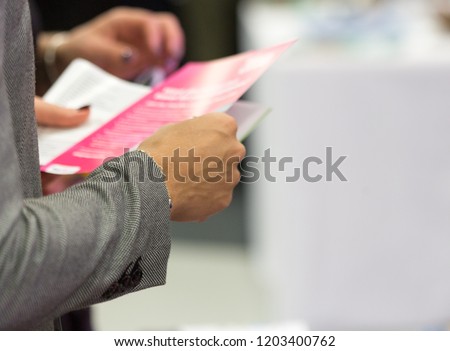 Female holding a leaflet, close up, blurred, space for text, isolated